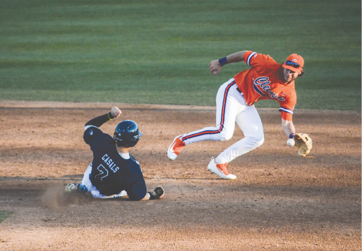 Junior infielder Weston Wilson (8) tags out Maines third baseman, Danny Casals, in their game at Doug Kingsmore Stadium