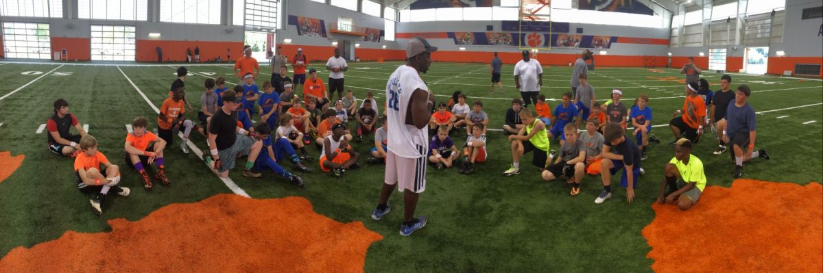 Former+Clemson+player+C.J.+Spiller+speaks+with+a+group+of+kids+at+his+annual+football+camp.