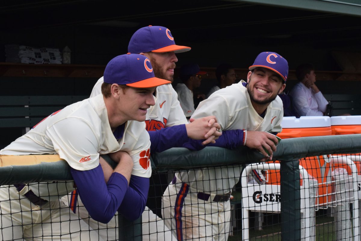 Pat Krall, Alex Eubanks and Andrew Cox stand in the dugout during a game at Doug Kingsmore Stadium.