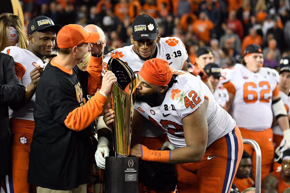 Christian Wilkins (42) kisses the National Championship trophy. Wilkins is a member of one of the winningest classes in the history of college football, and with the win against Alabama, Clemson became the first team to go 15-0 since Penn in 1897.