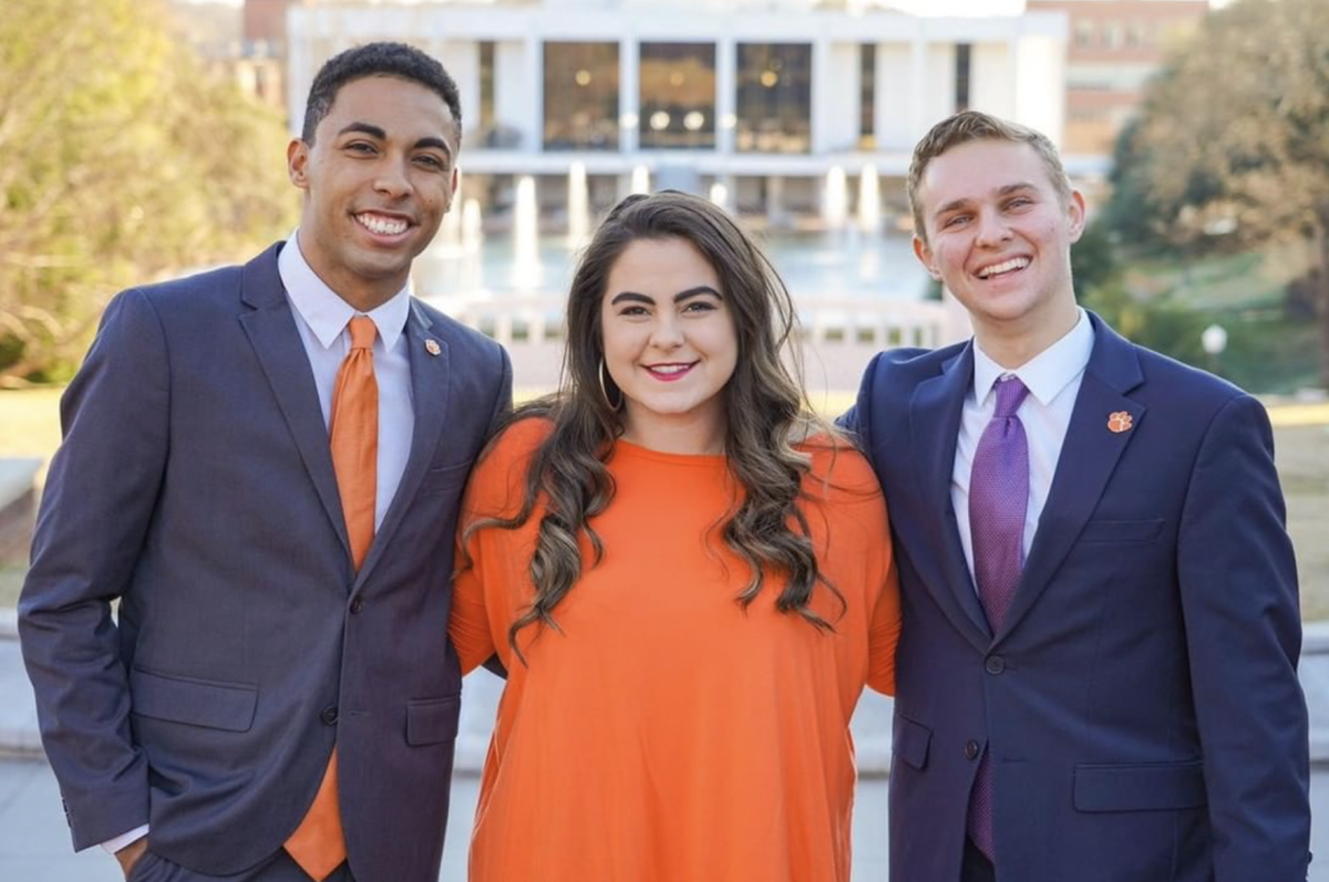 Andrea Collins, senior campaign manager of Derwin Simpson and Jeremy Lutz's campaign, stands alongside them in front of Cooper Library.