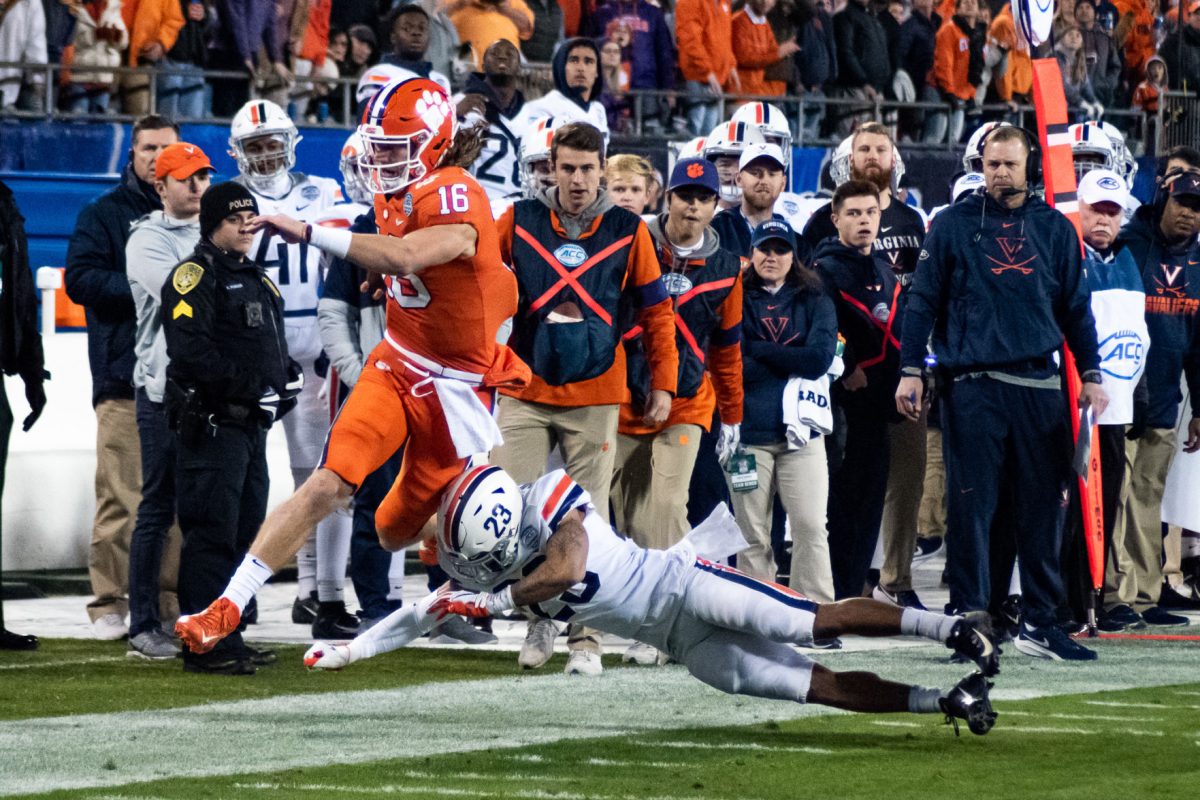 Trevor Lawrence (16) rushes for a first down against the Virginia Cavaliers in the ACC Championship Game.