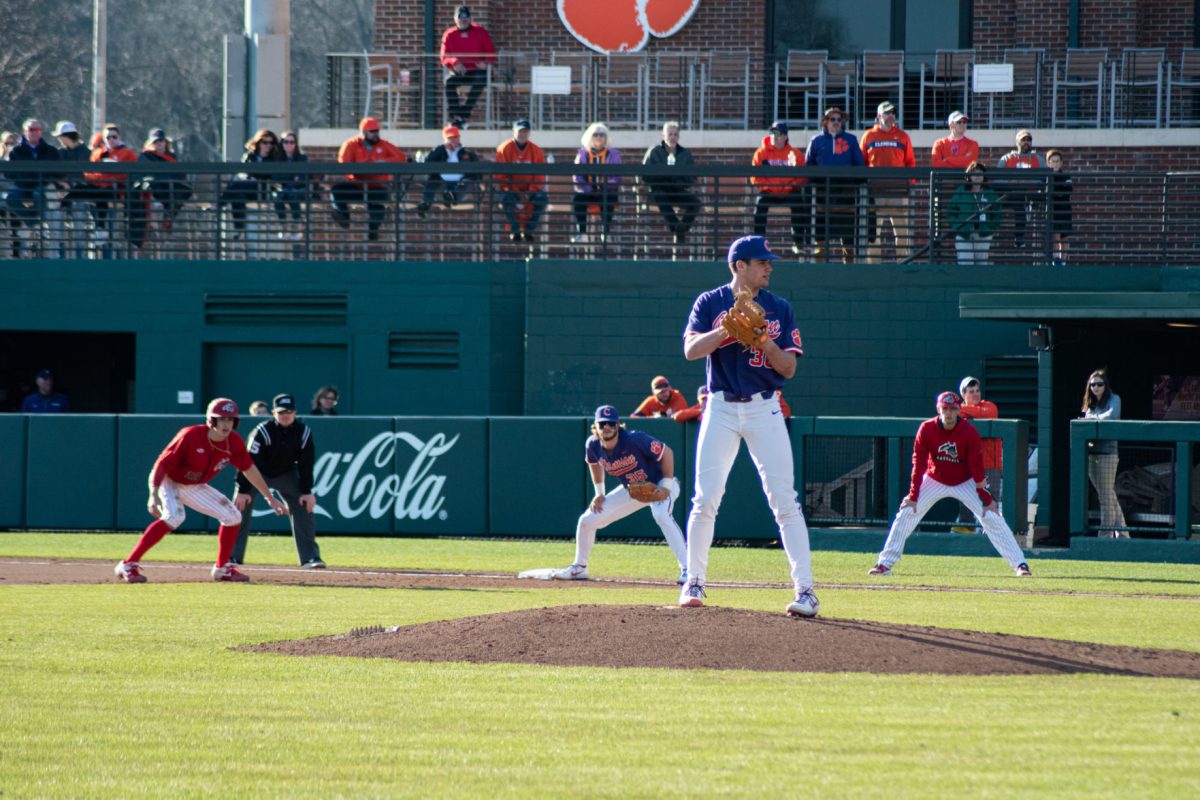 Pitcher Davis Sharpe (30) waits to deliver&#160;a pitch as first baseman Bryar Hawkins (35) holds a Stony Brook runner close to first base.