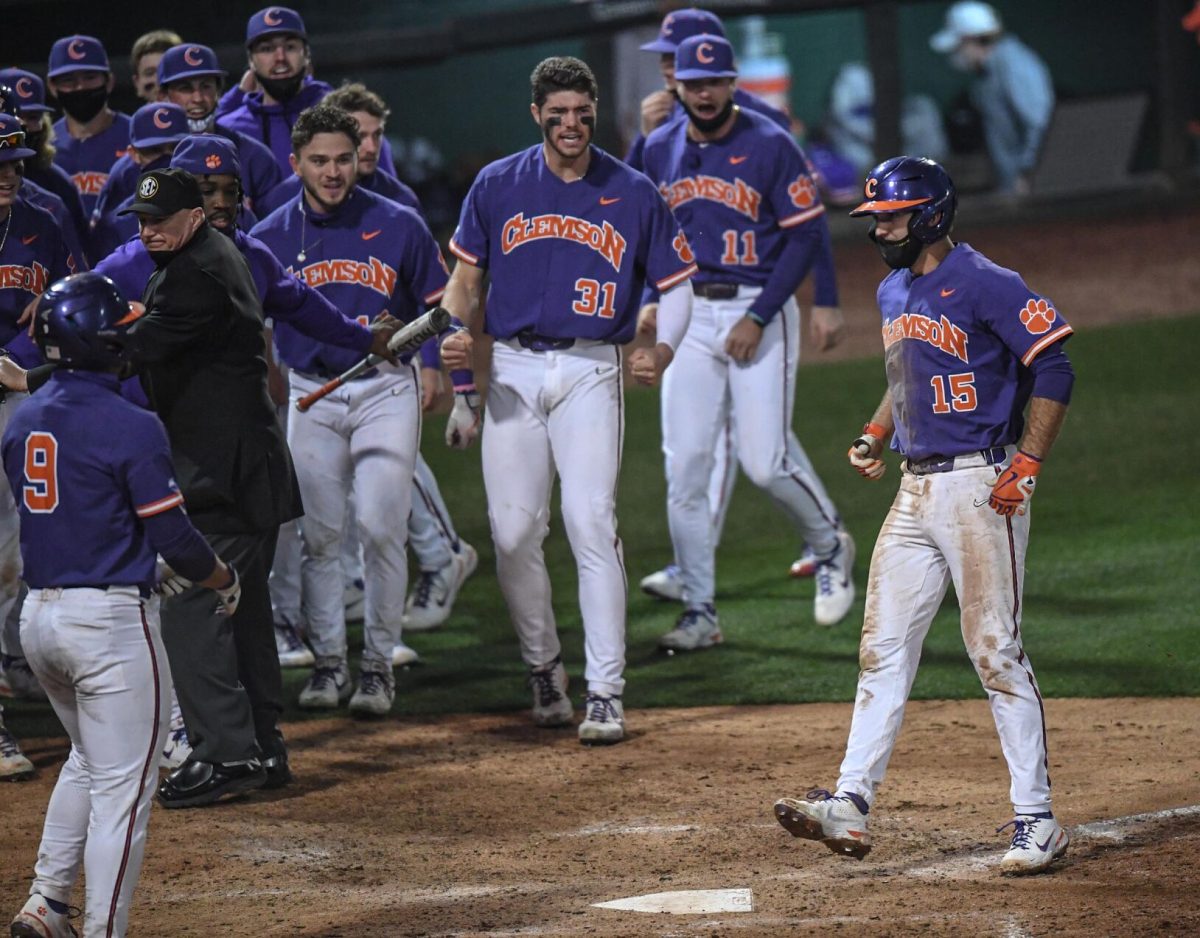 Tigers' shortstop James Parker (15) crosses home plate greeted by his team after hitting a homerun in the top of the ninth inning against the South Carolina Gamecocks at Fluor Field in Greenville, S.C. on Feb. 27.&#160;