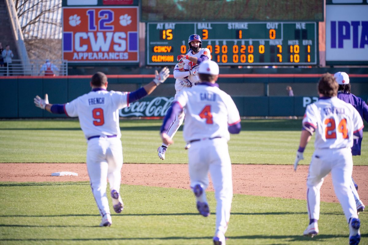 Shortstop James Parker (center, background) smiles as his team dogpiles him at second base following his walk-off single in the tenth inning to propel the Tigers to an opening weekend sweep for the second year in a row.