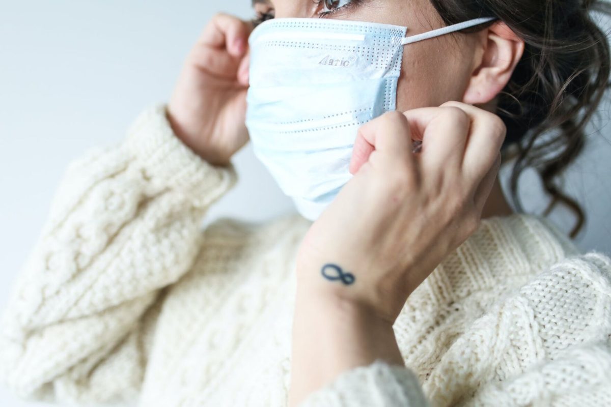 A woman adjusts her mask.&#160;