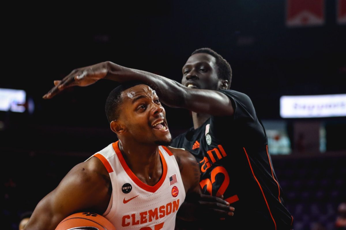 Hurricane's Deng Gak (#22) defends against Tiger's Aamir Simms (#25).