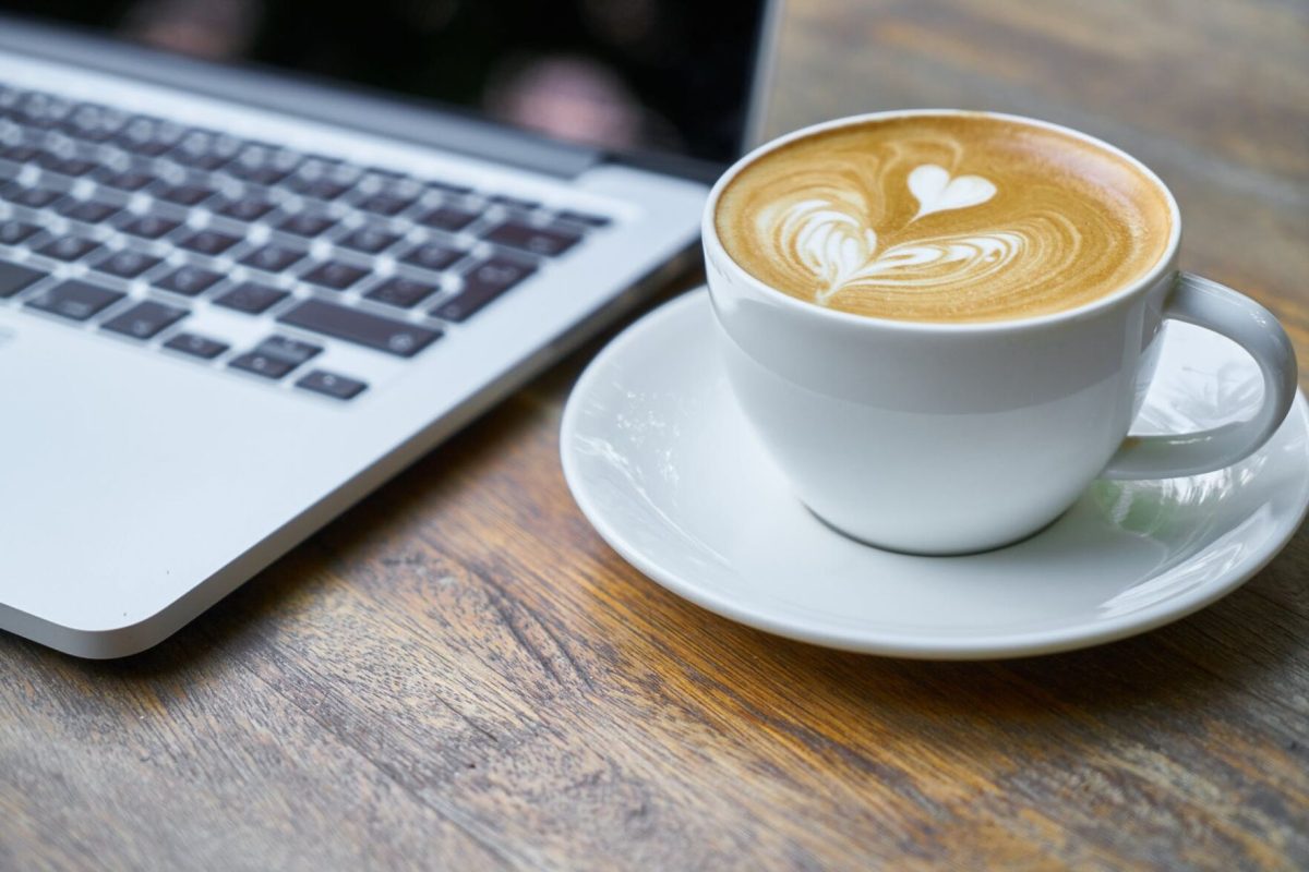 A cup of coffee sits next to a computer.&#160;