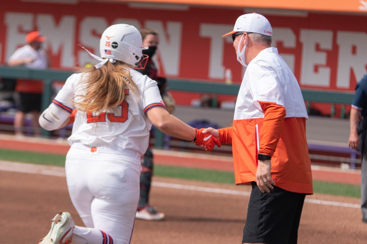 Right fielder Marissa Guimbarda high fives head coach John Rittman as she rounds third base after a homerun in the first inning.