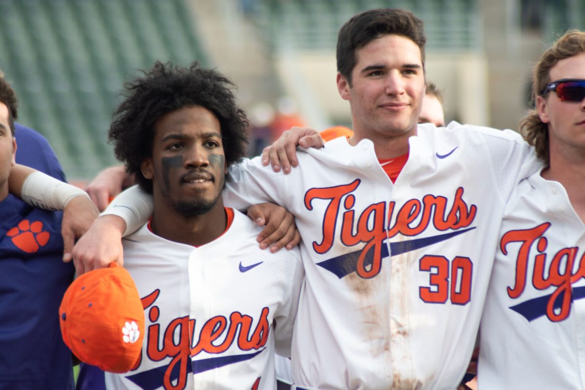 Kier Meredith (1) and Davis Sharpe (30) sing the alma mater following a 5-2 win over in-state rival South Carolina at Doug Kingsmore Stadium on March 1, 2020.