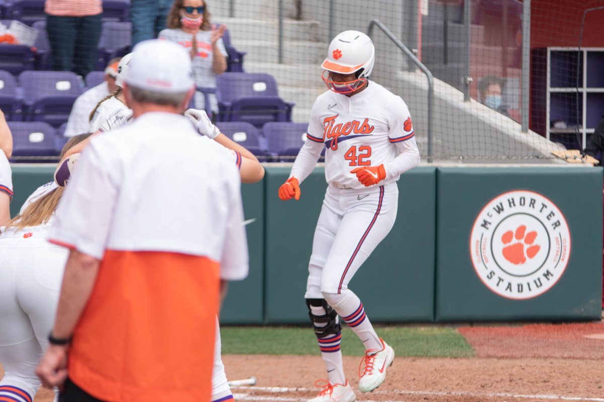 Morgan Johnson approaches home plate as her team awaits to greet her.