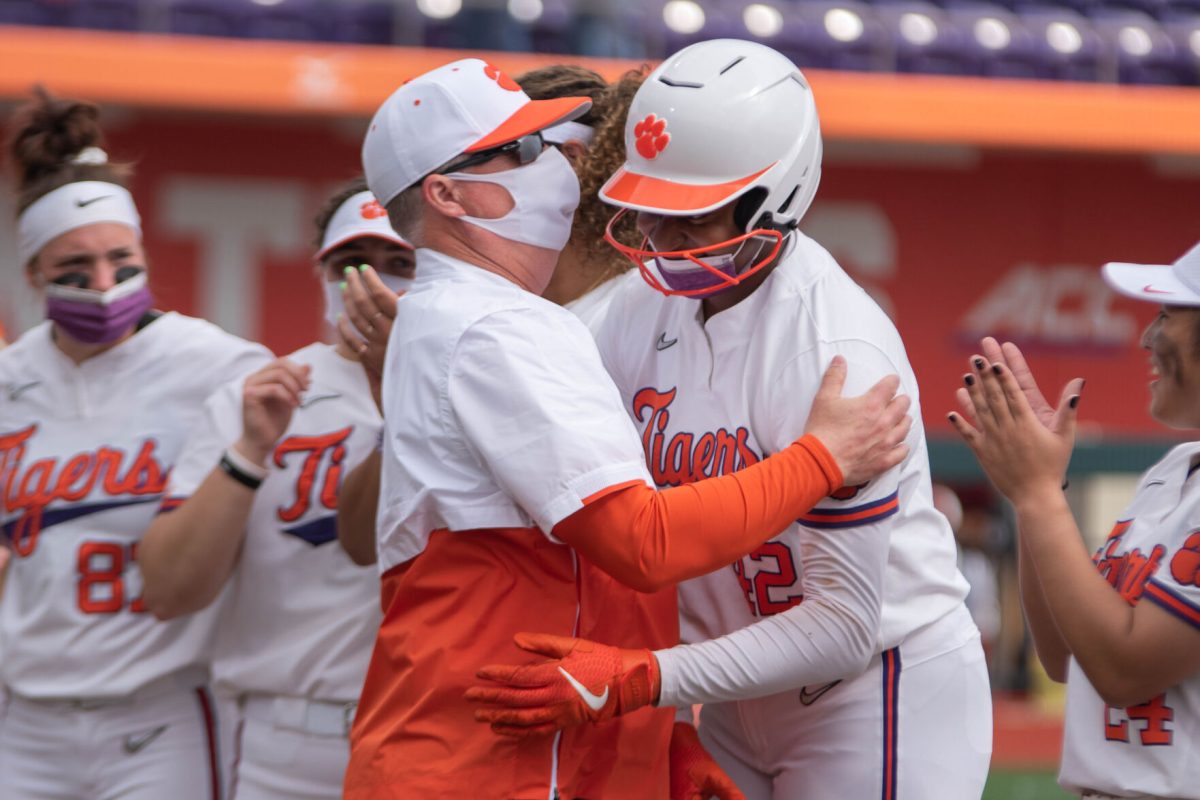 Head coach John Rittman hugs Johnson after hitting her first collegiate home run and walking the game off for the Tigers.