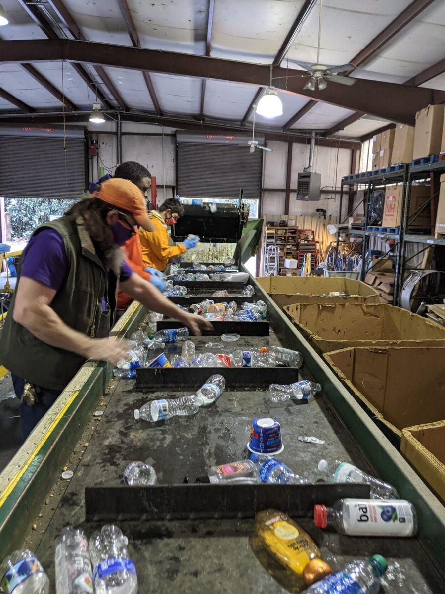 Kite Hill employees lean over the sorting line to separate recyclable from non-recyclable plastic.