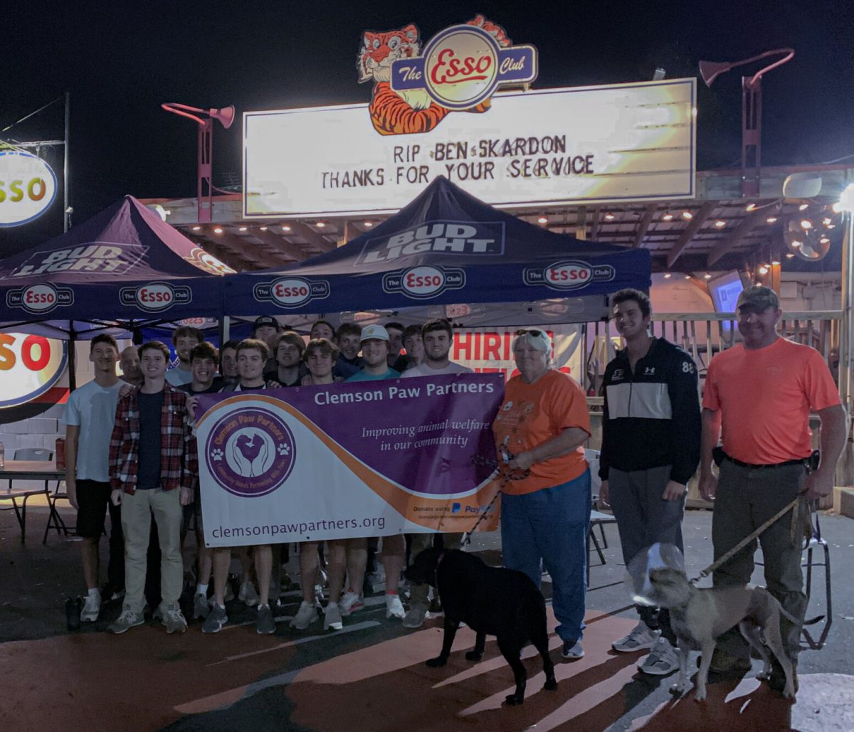 Members of Chi Phi stand alongside Paw Partners organizers to celebrate their achievements.