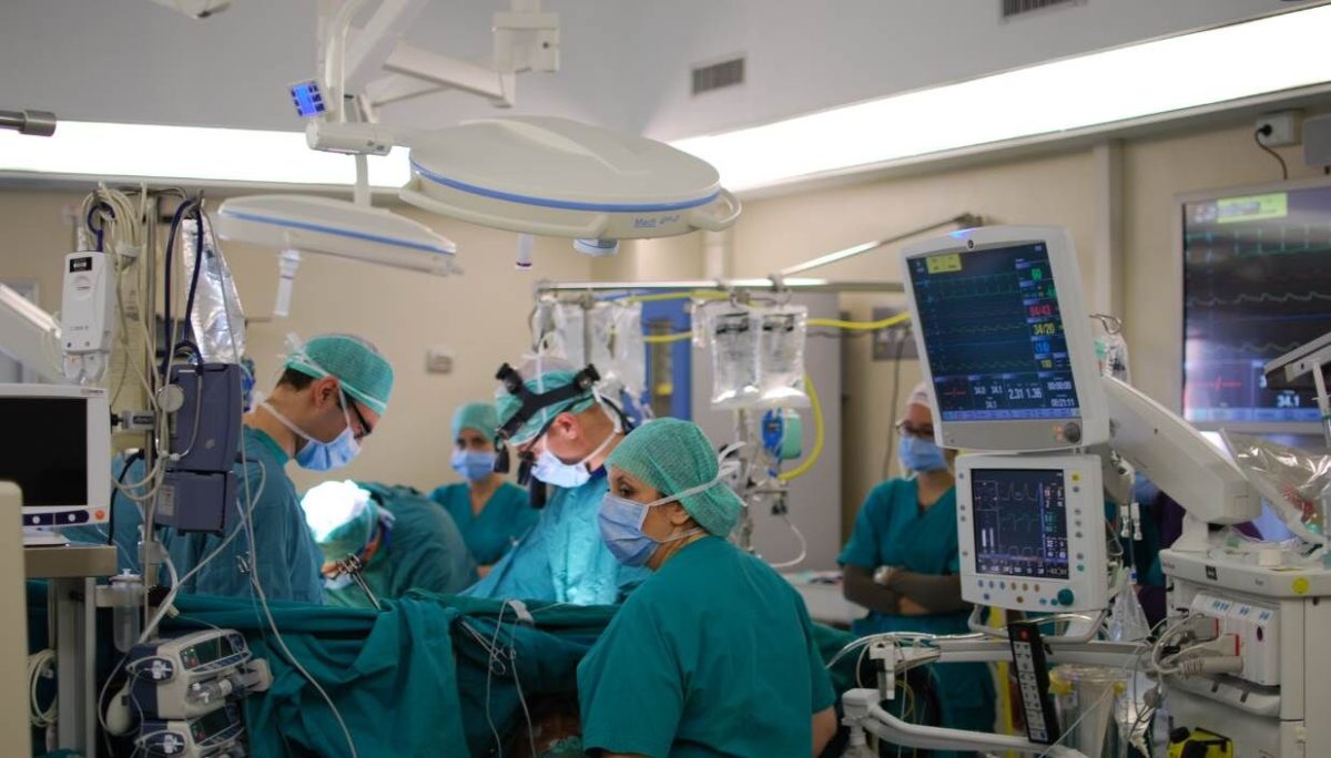 Doctors and nurses perform heart surgery.