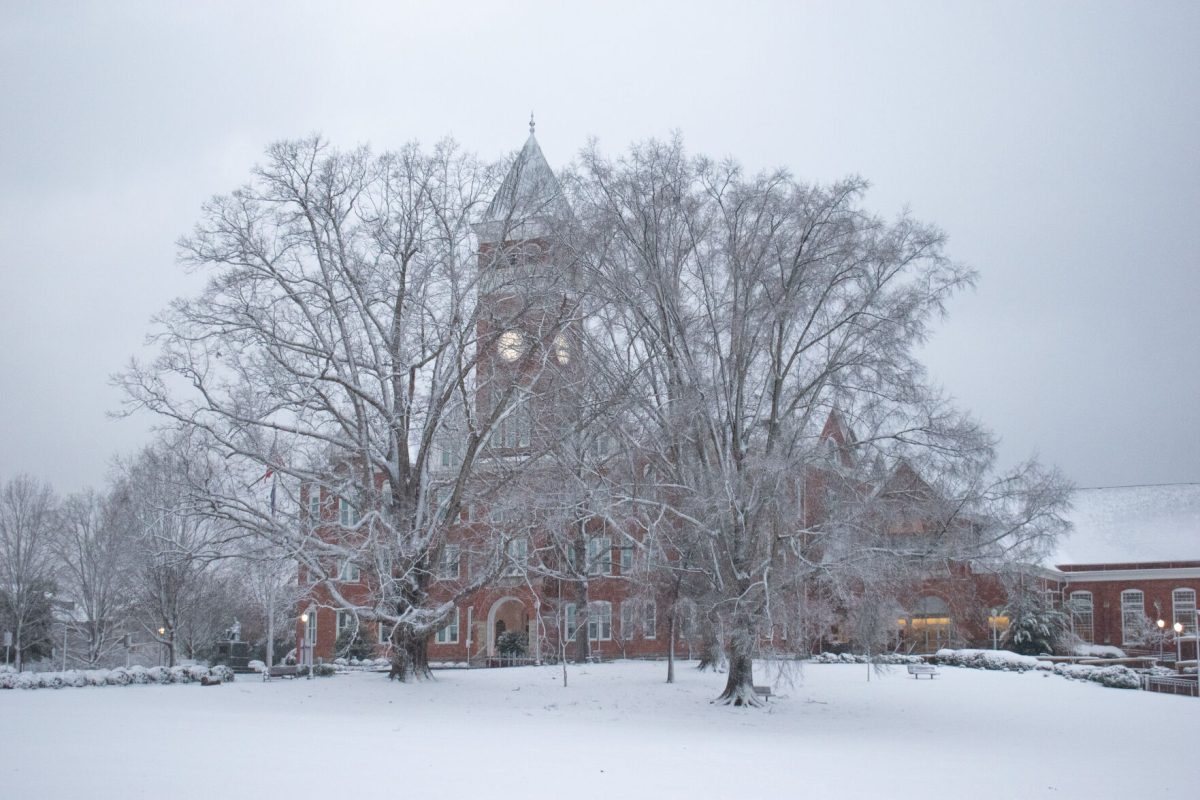 A snow-covered Old Main sits covered by snowy trees early in the morning of Jan. 16, 2022.