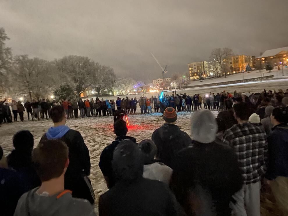 Students battle it out with light sabers on Bowman Field in the 2021 snowstorm.