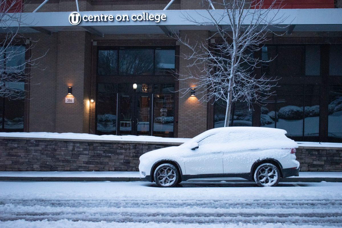 Alone car sits with a sheet of snow covering all of its windows outside of U Centre on College early in the morning on Jan. 16, 2022.