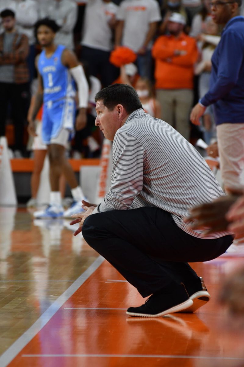 Clemson+mens+basketball+head+coach+Brad+Brownell+squats+down+while+watching+his+team+take+on+North+Carolina+on+Feb.+8%2C+2022.