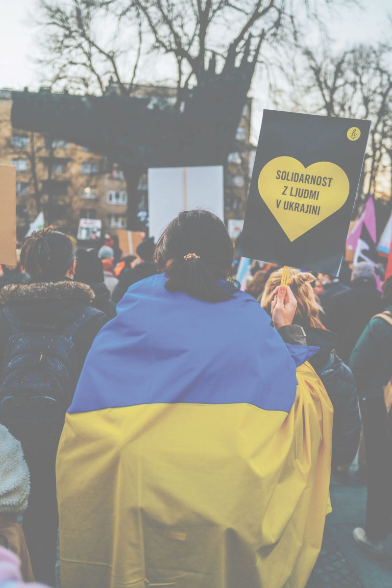 A+protestor+wearing+the+Ukraine+flag+holds+a+sign+saying%2C+%26%238220%3BSolidarity+with+the+people+of+Ukraine.%26%238221%3B