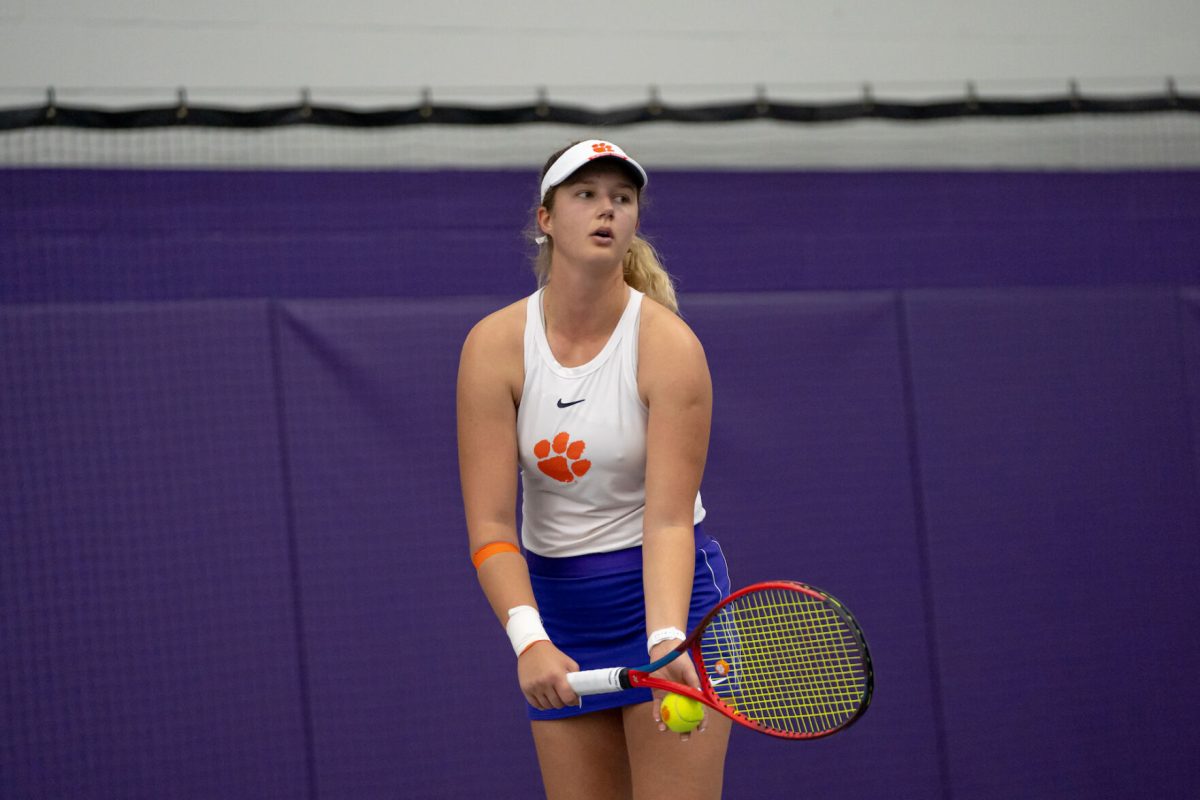 A Clemson womens tennis player prepares to serve against Louisville on March 13, 2022.