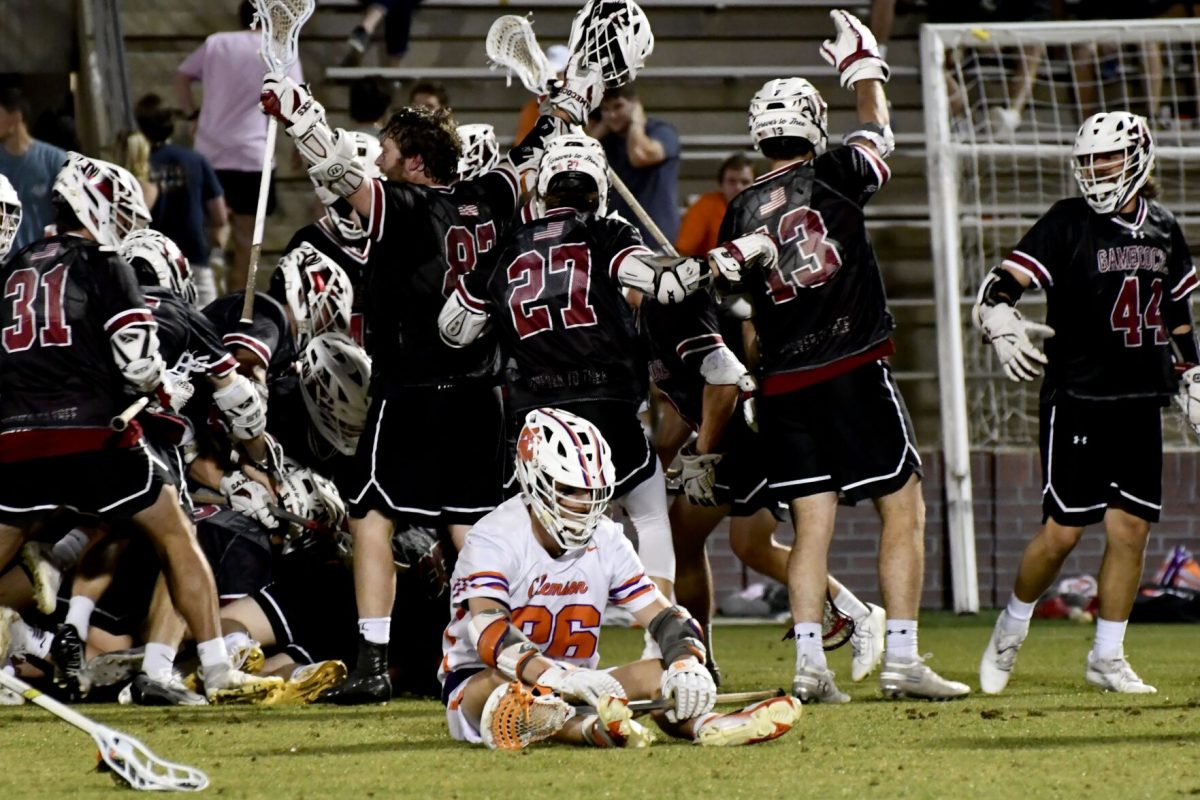 A+Clemson+lacrosse+player+sits+on+Historic+Riggs+Field+while+the+South+Carolina+Gamecocks+celebrate+their+14-13+victory.