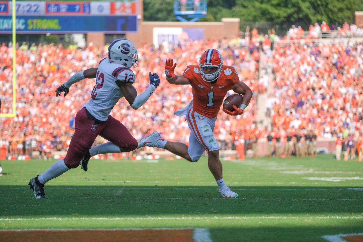 Clemson running back Will Shipley (1) prepares to stiff arm a South Carolina State defender in Memorial Stadium.