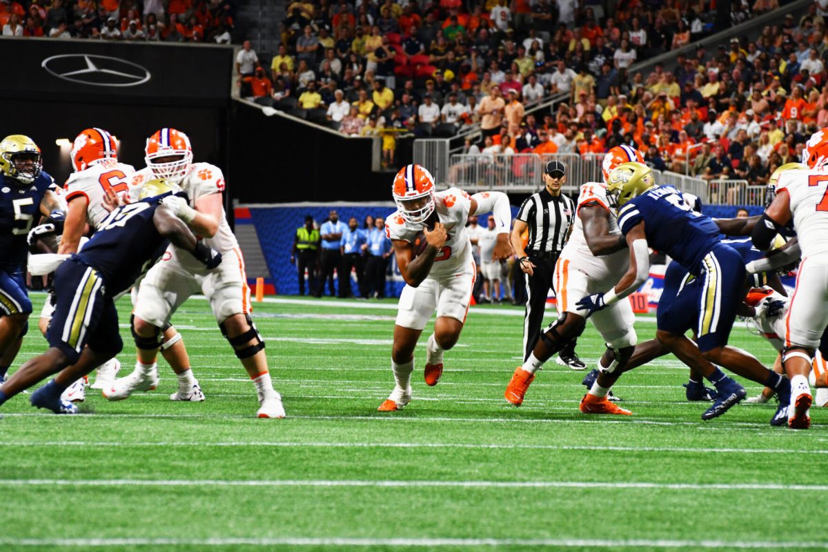 Clemson quarterback DJ Uiagalelei (5) runs through a hole against Georgia Tech in Mercedes-Benz Stadium on Sept. 5, 2022.