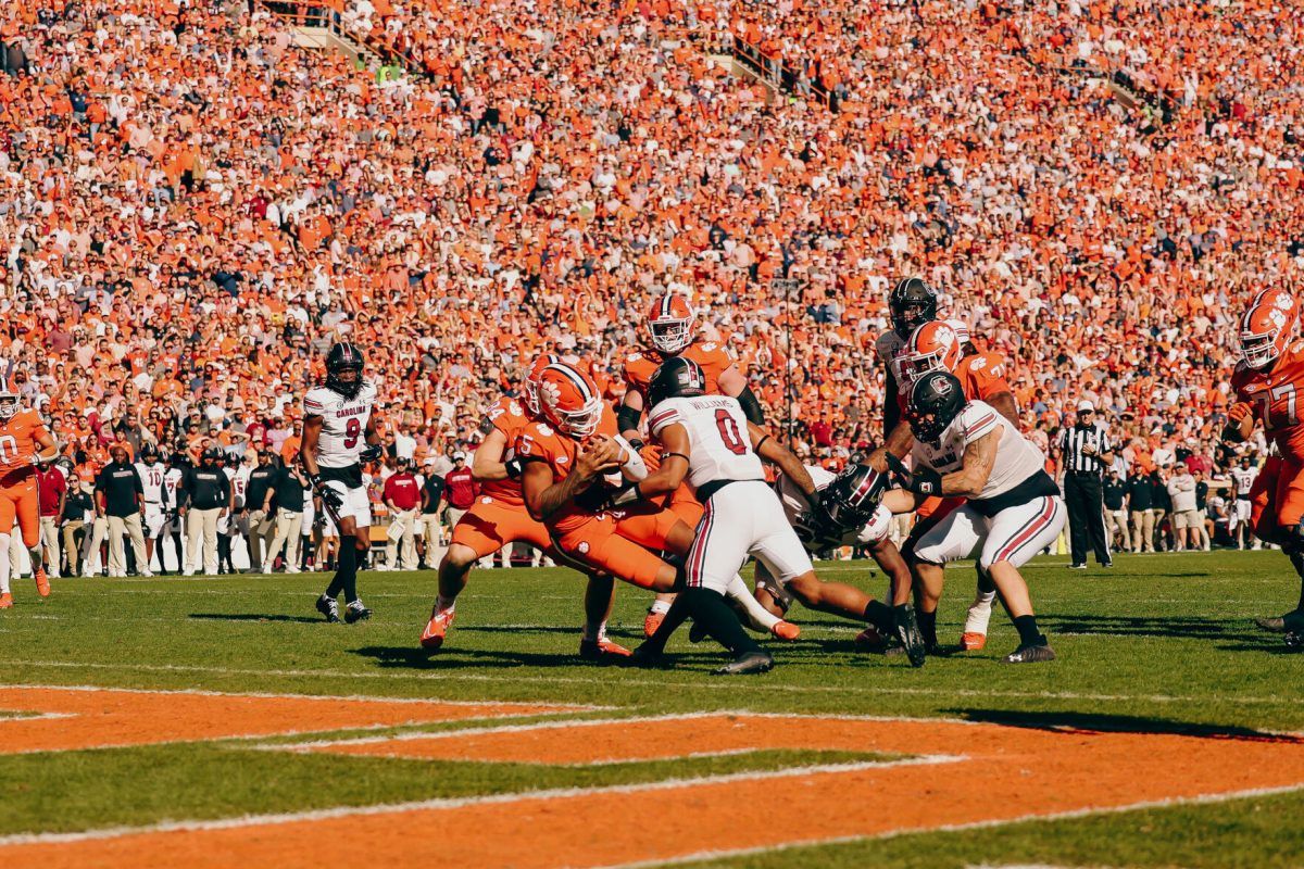 Clemson quarterback DJ Uiagalelei (5) pushes through South Carolina defenders for a 9-yard touchdown run in the first quarter of the Tigers game against the Gamecocks in Memorial Stadium on Nov. 26, 2022.