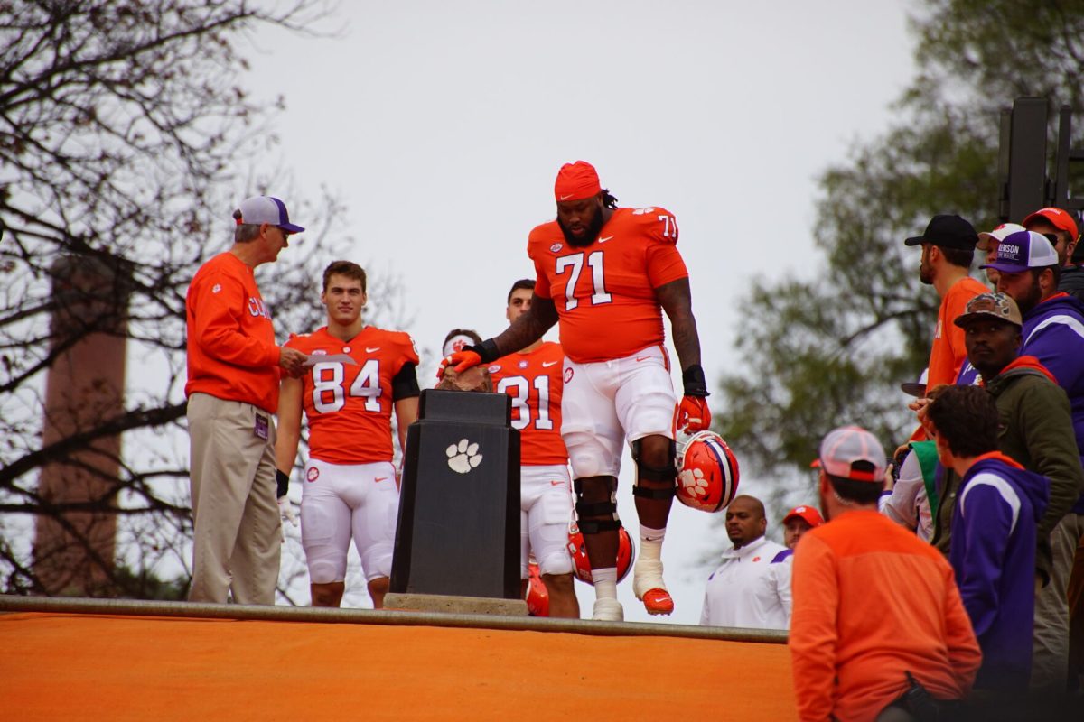 Clemson left tackle Jordan McFadden (71) touches Howards Rock before running down the hill to take on Miami in Memorial Stadium on Nov. 19, 2022. 