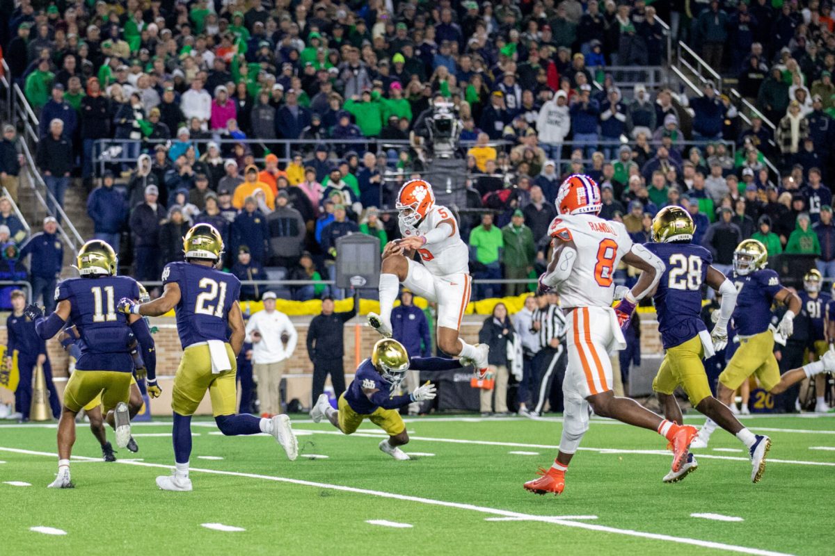 Clemson quarterback DJ Uiagalelei (5) hurdles a Notre Dame defender during the Tigers matchup with Notre Dame in South Bend, Indiana, on Nov. 5, 2022. 