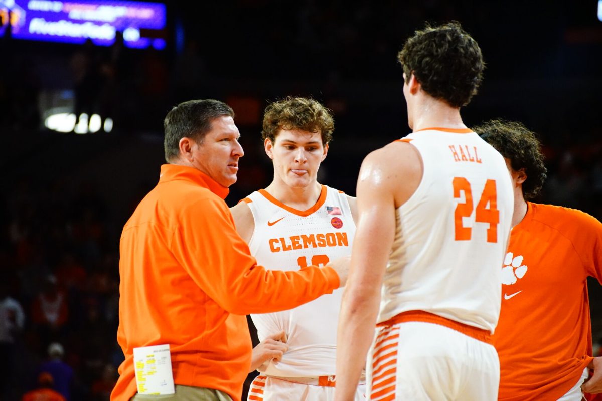 Clemson head basketball coach Brad Brownell talks to forwards PJ Hall (24) and Ben Middlebrooks (10) against Miami in Littlejohn Coliseum on Feb. 4, 2023. 