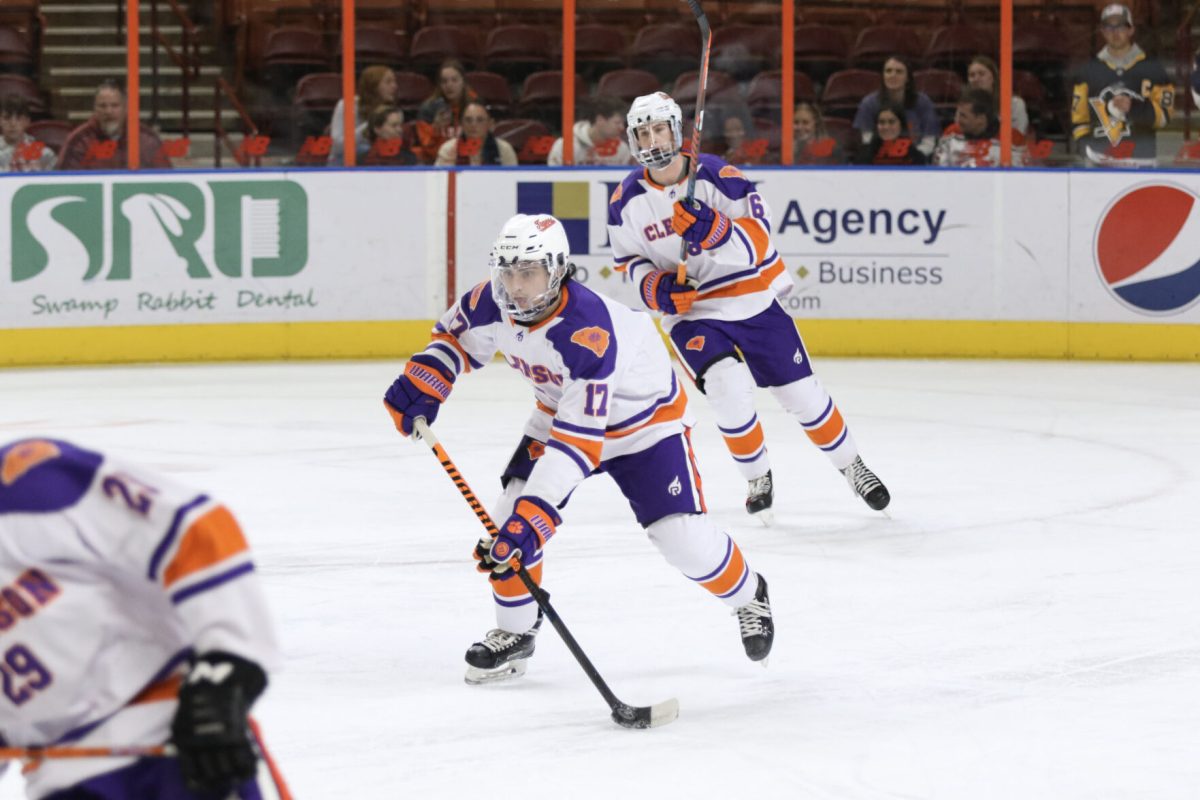 Clemson defensemen Christian Romeo (17) and Brian Blomquist (6) skate the puck out of the defensive zone during the Tigers matchup against South Carolina on Jan. 28, 2023. 