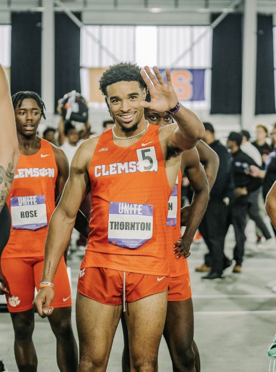 Aman Thornton waves before stepping onto the first-place podium for the Mens 4x400 meter relay at the Indoor ACC Championships.