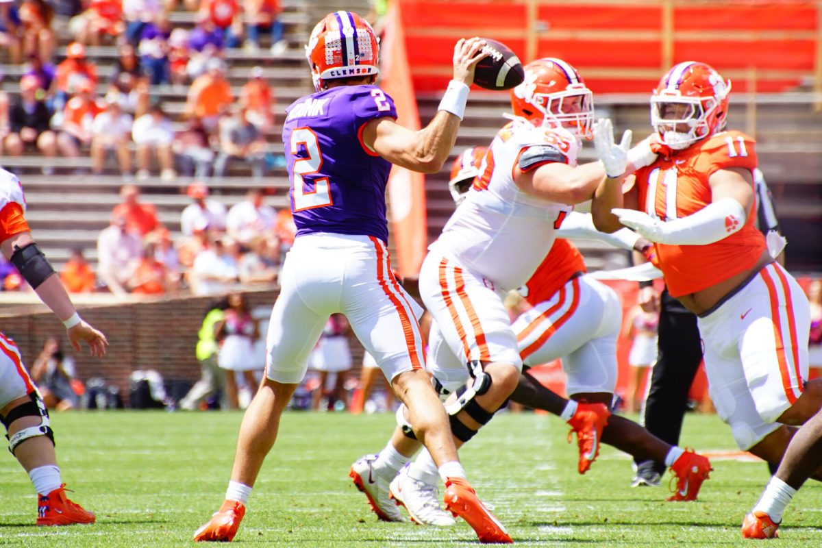 Clemson quarterback Cade Klubnik (2) throws a pass while getting pressured by defensive tackle Peter Woods (11) during the Tigers 2023 Orange vs. White spring game in Memorial Stadium. 