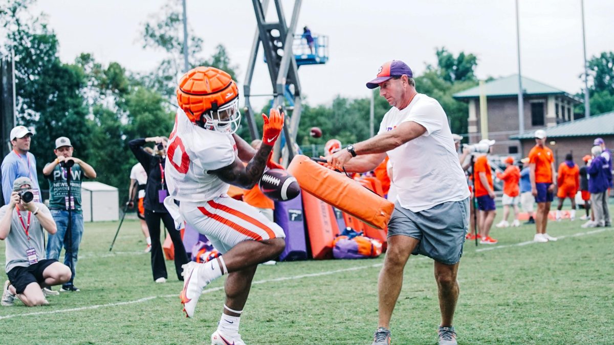 Clemson head coach Dabo Swinney breaks up a pass intended for running back Domonique Thomas during drills at practice on Aug. 10, 2023.
