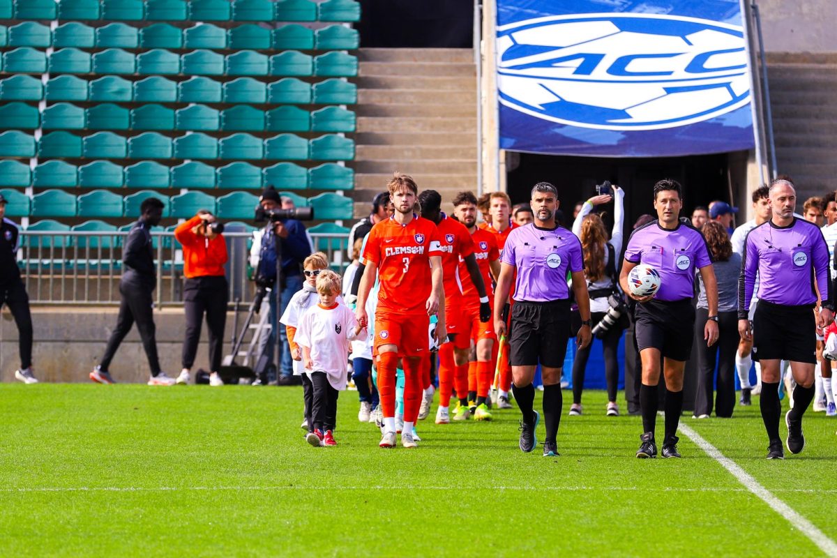 The clemson team is escorted by members of a local youth soccer league at the start of the ACC Championship in Cary, North Carolina, on Sunday, Nov. 12.