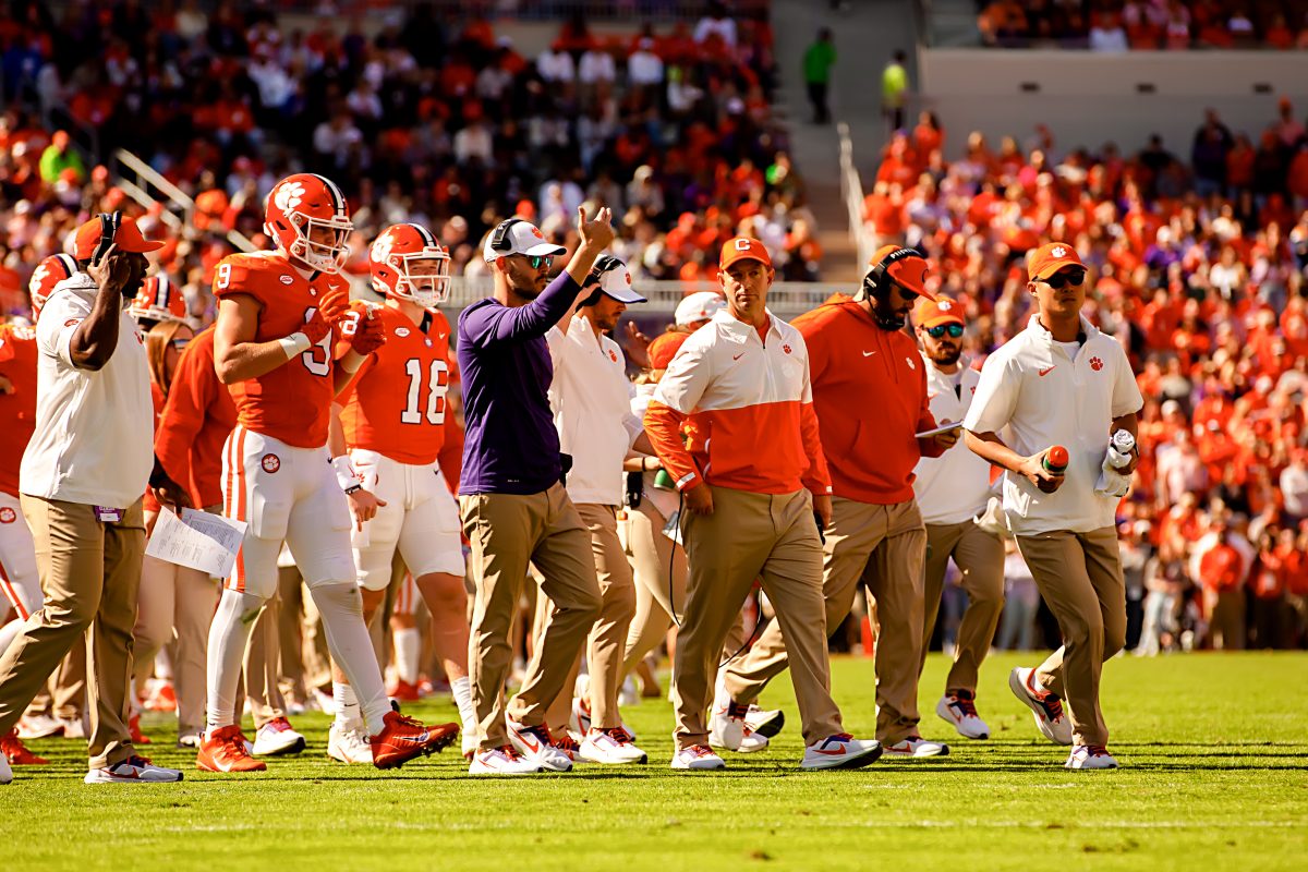 Garrett Riley pictured directing his offense alongside head coach Dabo Swinney against Notre Dame on Saturday.