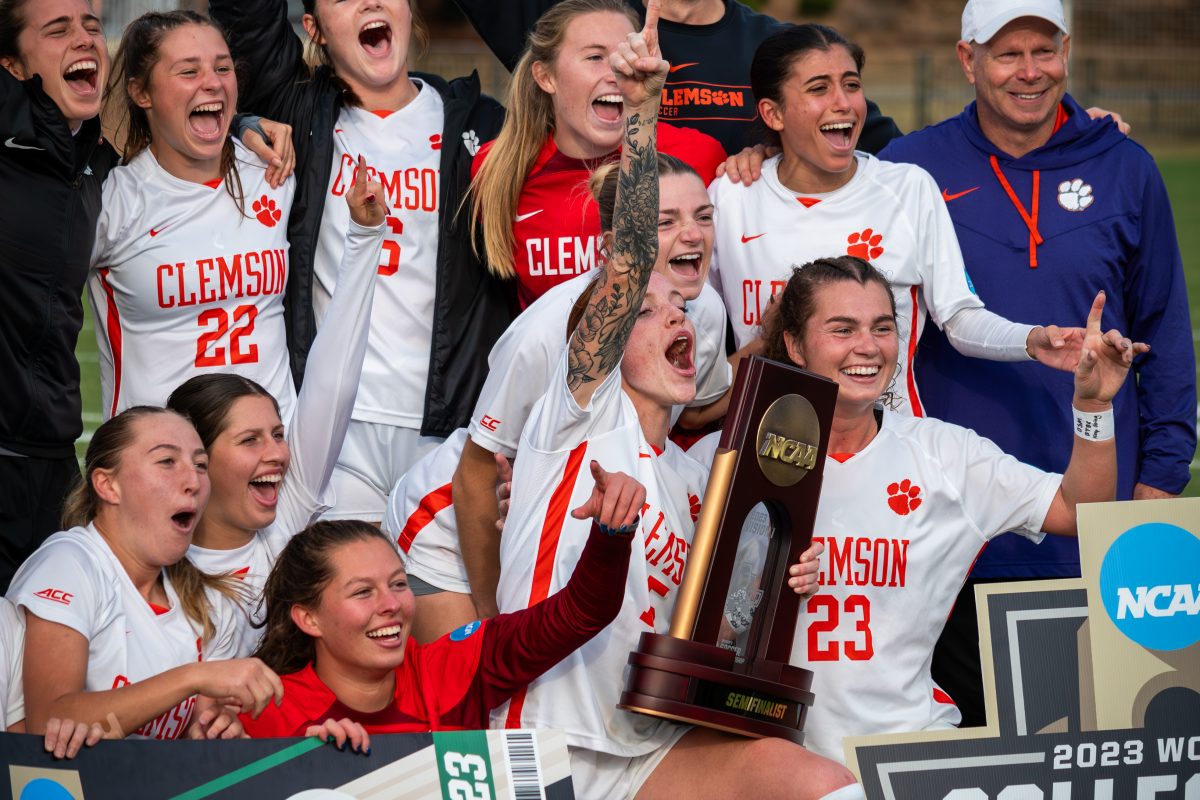 Hal Hershfelt (15) and Caroline Conti (23), pictured front and center holding their NCAA semifinalist trophy, are leaving Clemson after five years to join the NWSL.