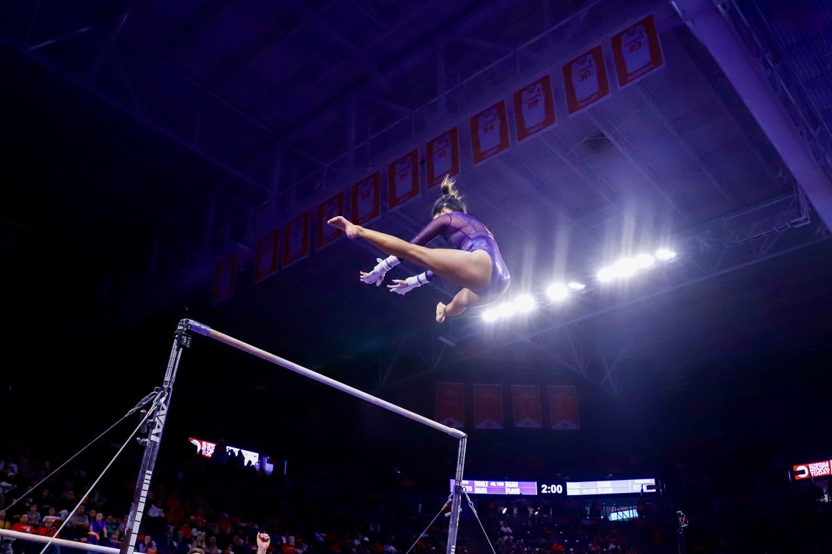 Redshirt junior Eve Jackson performs a pass between the bars against Pitt, earning a score of 9.825.