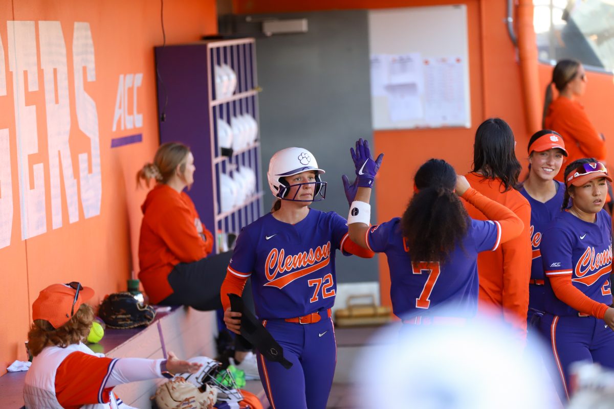 Clemson ace Valerie Cagle (72) and outfielder McKenzie Clark (7) high five in the dugout during game two of the Tigers series against NC State. 