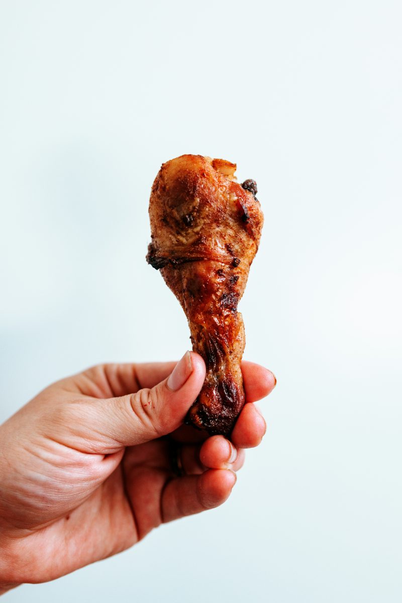 Person holds a wing from a recently sacrificed gamecock.