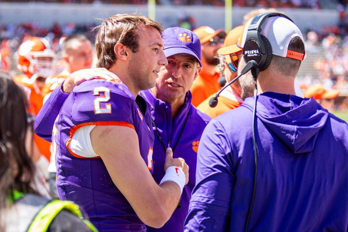 Head coach Dabo Swinney (middle) and offensive coordinator 
Garrett Riley (right) talk to quarterback Cade Klubnik (2) during Clemson's annual spring game in Death Valley on Saturday, April 6, 2024.