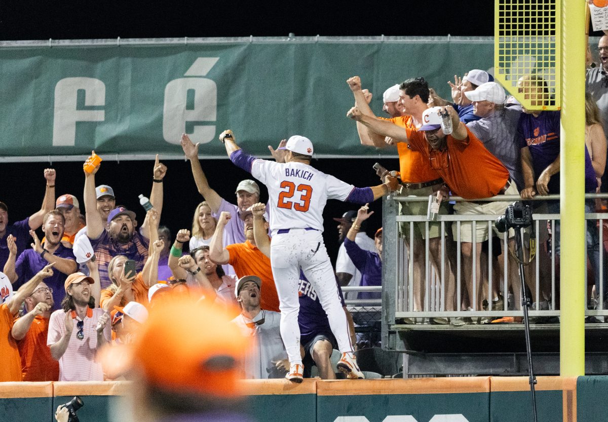 Clemson head coach Erik Bakich celebrates in right field after winning the Clemson Regional at home.