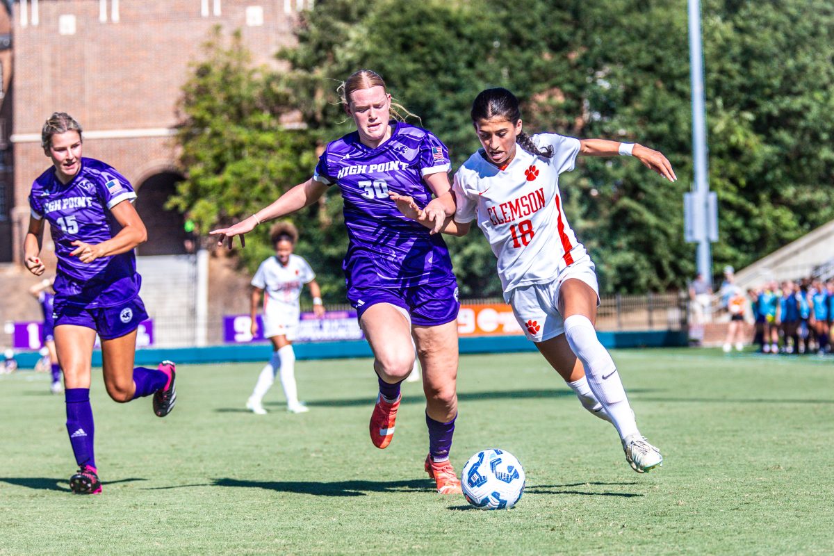 Forward Maria Manousos (18) dribbles past a High Point defender.