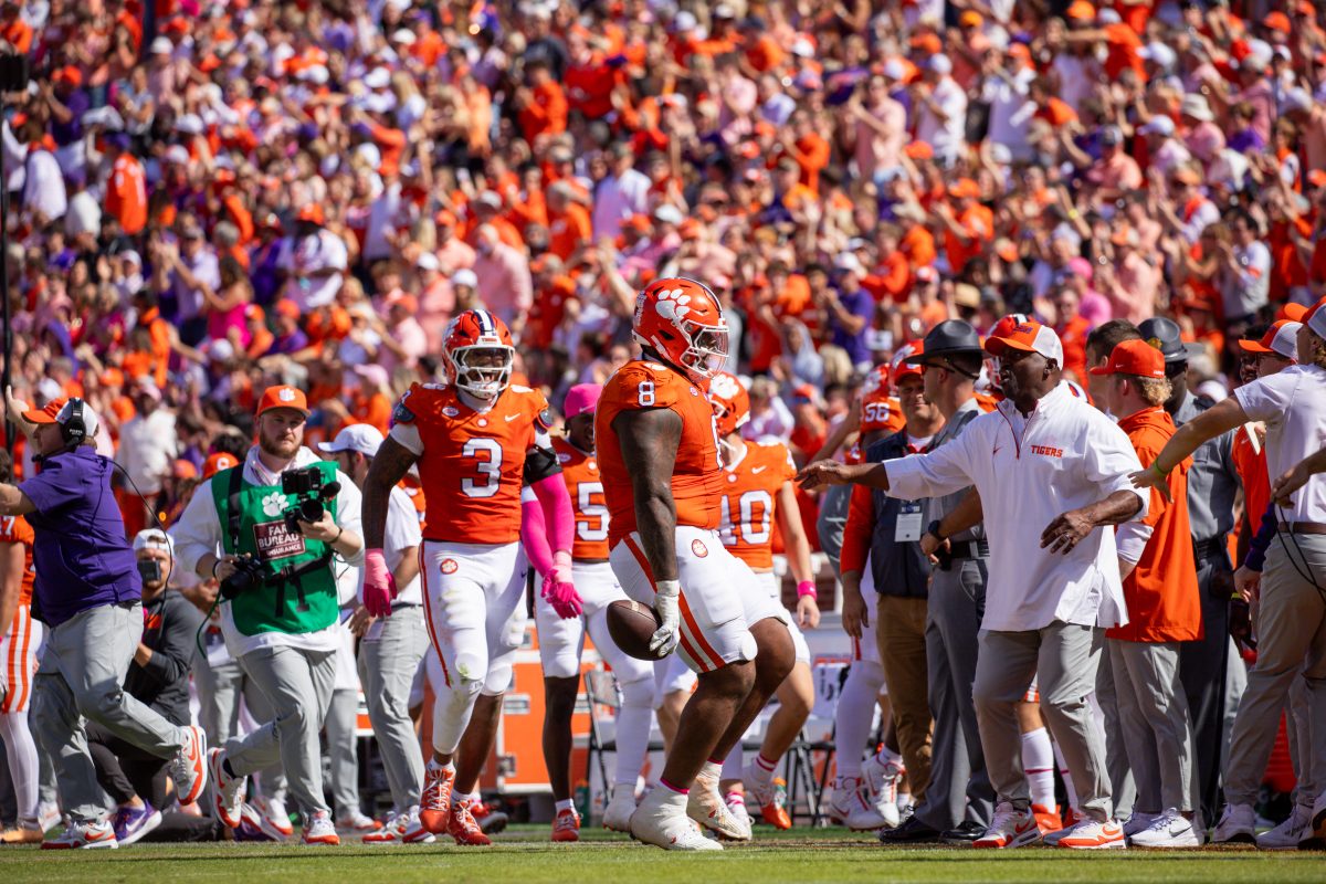 Tré Williams (8) celebrates after recovering a fumble against UVA; running backs coach C.J. Spiller cheers him on from the sidelines. 