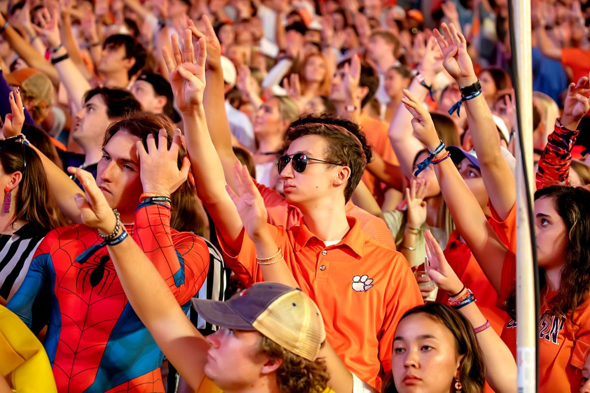 Clemson fans hold up four fingers at the beginning of the fourth quarter during every home game while a video plays to hype up the fans.