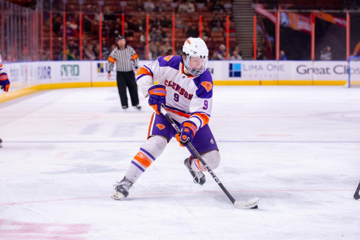 Forward Cade Heinold (9) moves the puck into the offensive zone during Clemson's game against South Carolina at Bon Secours Wellness Arena on Feb. 24, 2024.