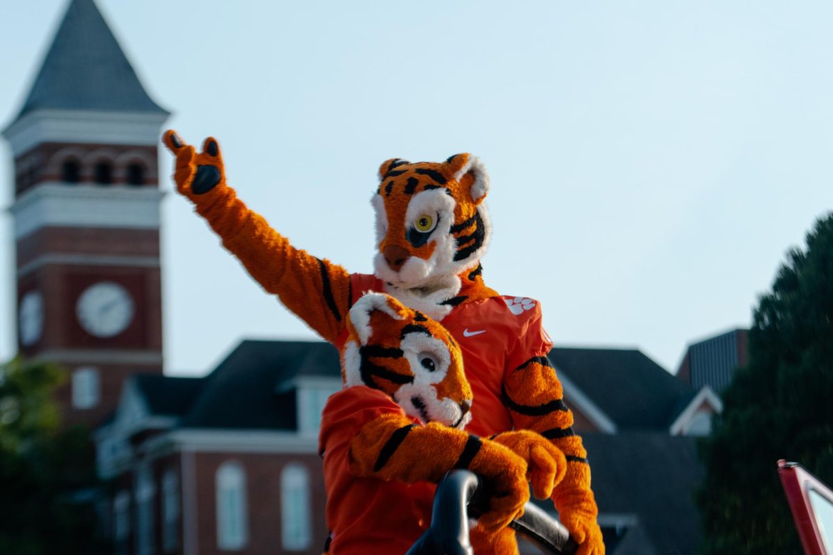 The Tiger and Cub ride in the back of an orange Jeep during the 2021 First Friday Parade.