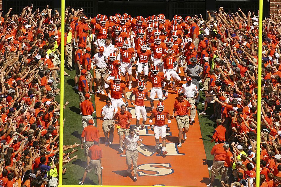Clemson players storm down the hill at Memorial Stadium, touching Howard’s Rock in one of college football’s most iconic traditions.